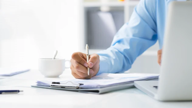 Rådgiver i arbeid med notater, dokumenter og laptop – strukturert planlegging og full kontroll på firmareiser fra et reisebyrå for bedrifter. Rådgiver i arbeid med notater, dokumenter og laptop – strukturert planlegging og full kontroll på firmareiser fra et reisebyrå for bedrifter.